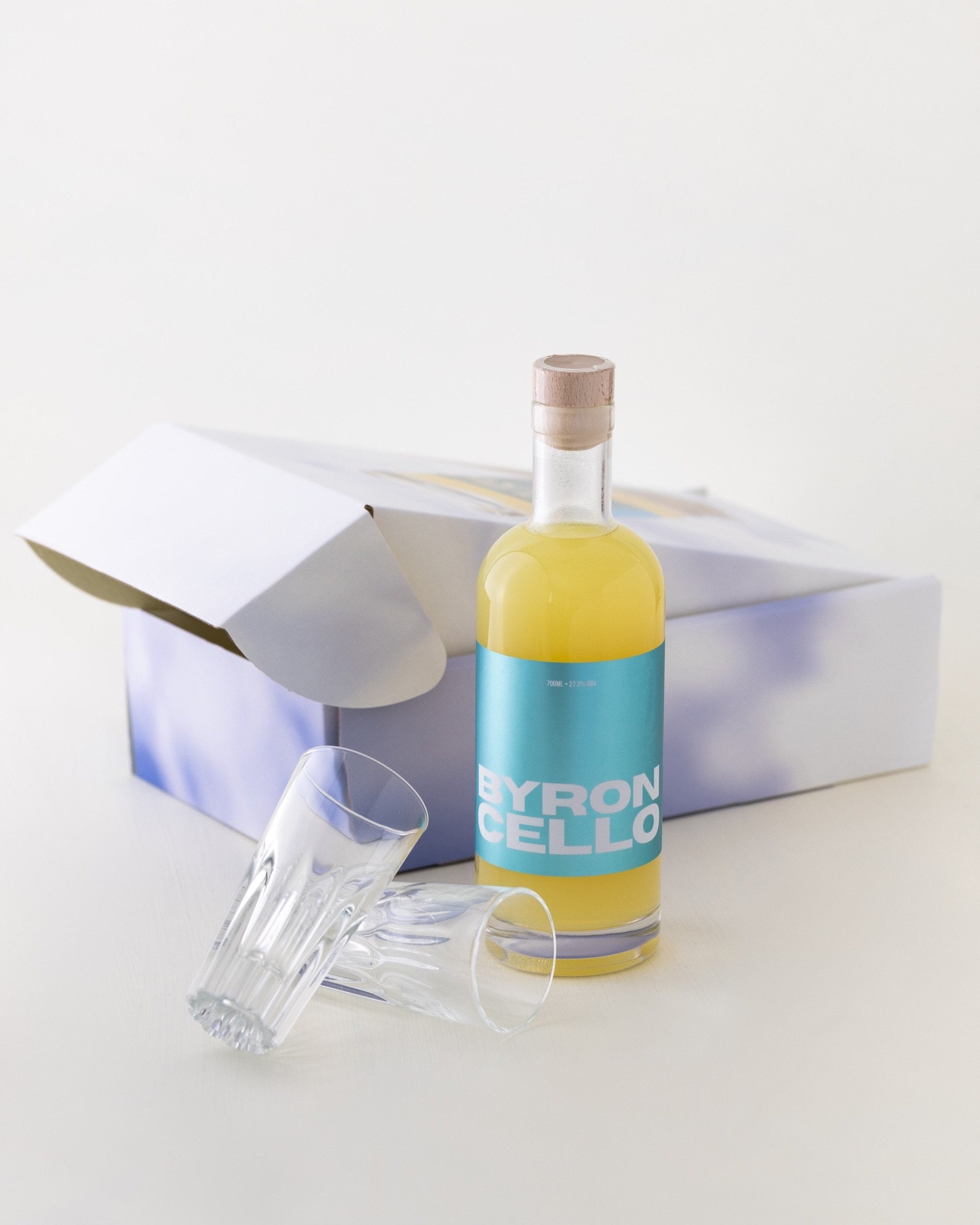 Bottle of Byroncello with a closed gift box and two Italian limoncello glasses